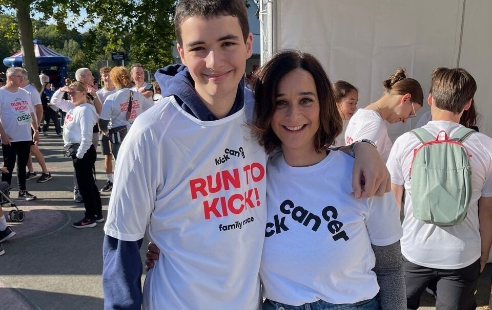 Delphine Heenen and her son Raphaël smiling together at RUN TO KICK 2024, wearing event T-shirts.