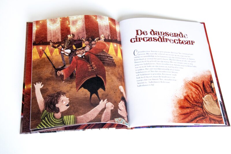 Open illustrated spread from the children’s book “Circus Crocket,” showing a circus ringmaster performing in a brightly lit tent. A page of text appears on the right. The book supports KickCancer through its sales.