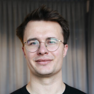 Portret van Ward, Kicker-in-Empowerment bij KickCancer, glimlachend voor een neutrale achtergrond.